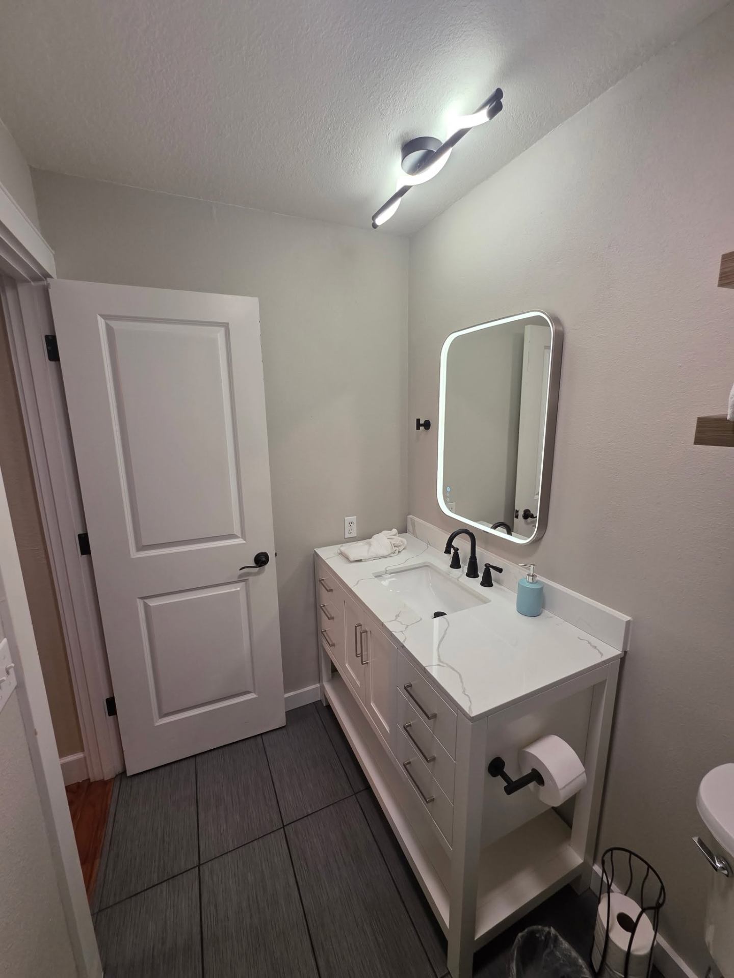 Custom white vanity with quartz counter and LED mirror in Chelan bathroom remodel