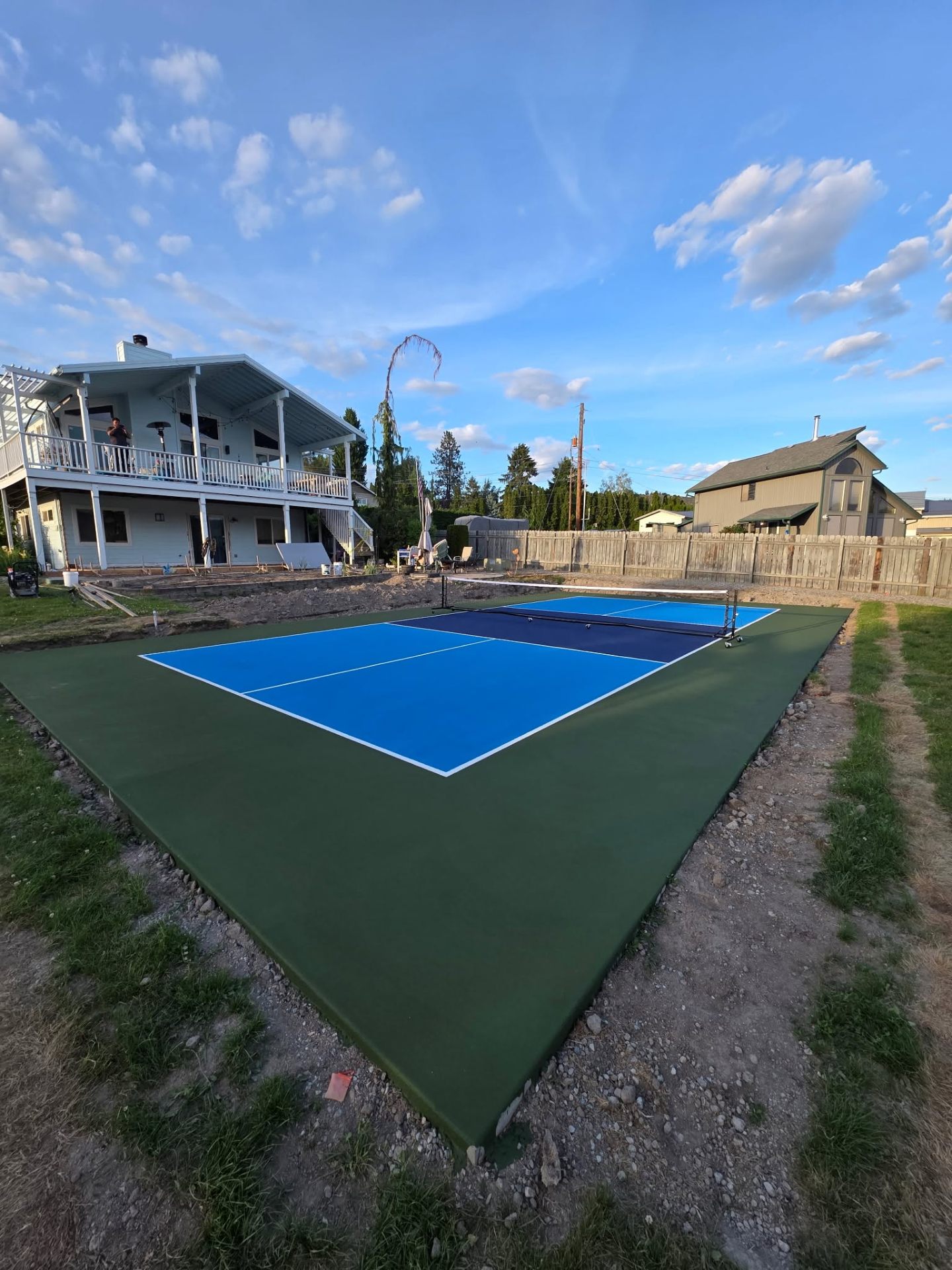 Completed backyard pickleball court with green surround in Chelan WA