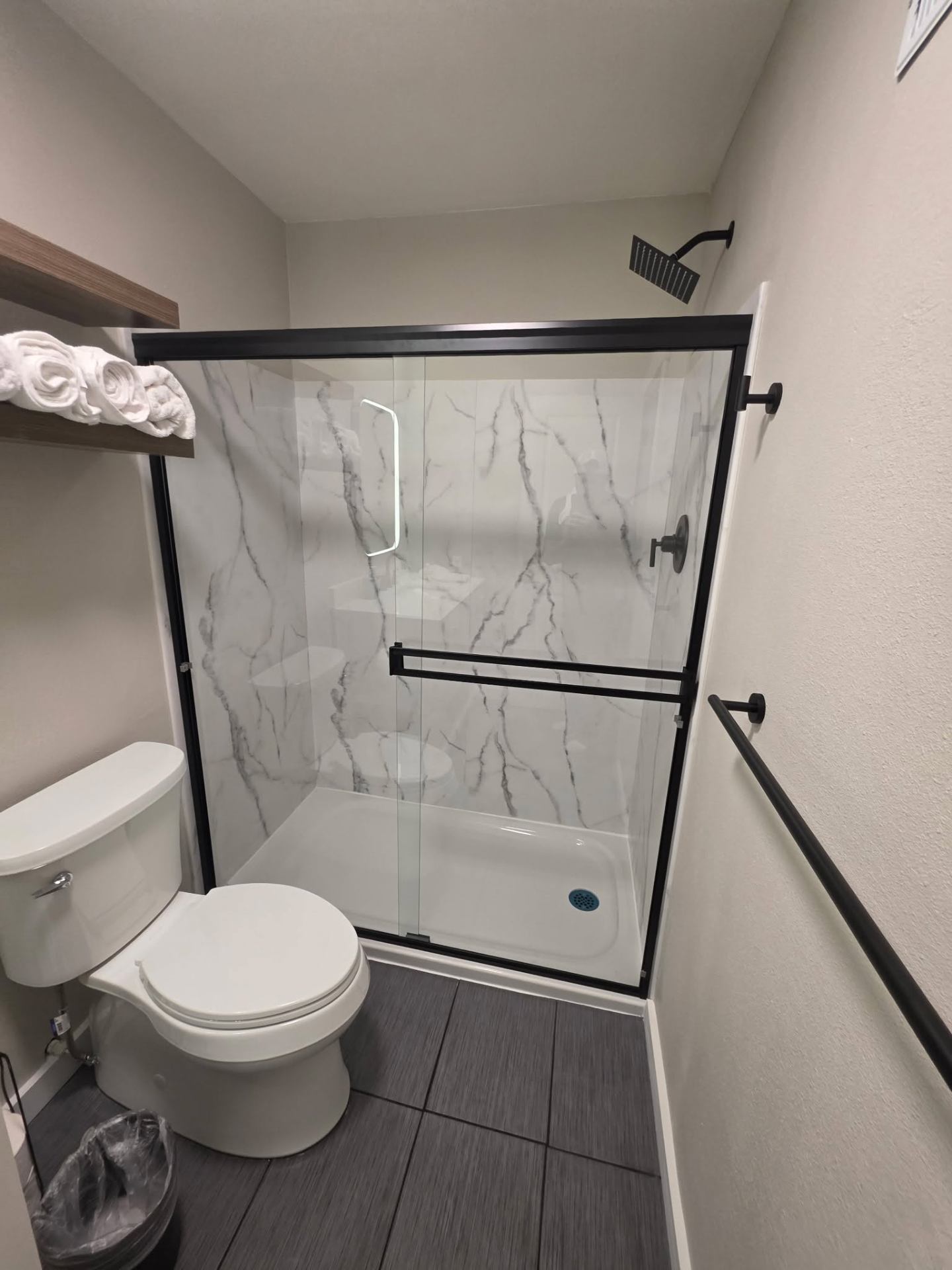 Glass sliding shower door and rainfall shower head in remodeled Chelan bathroom