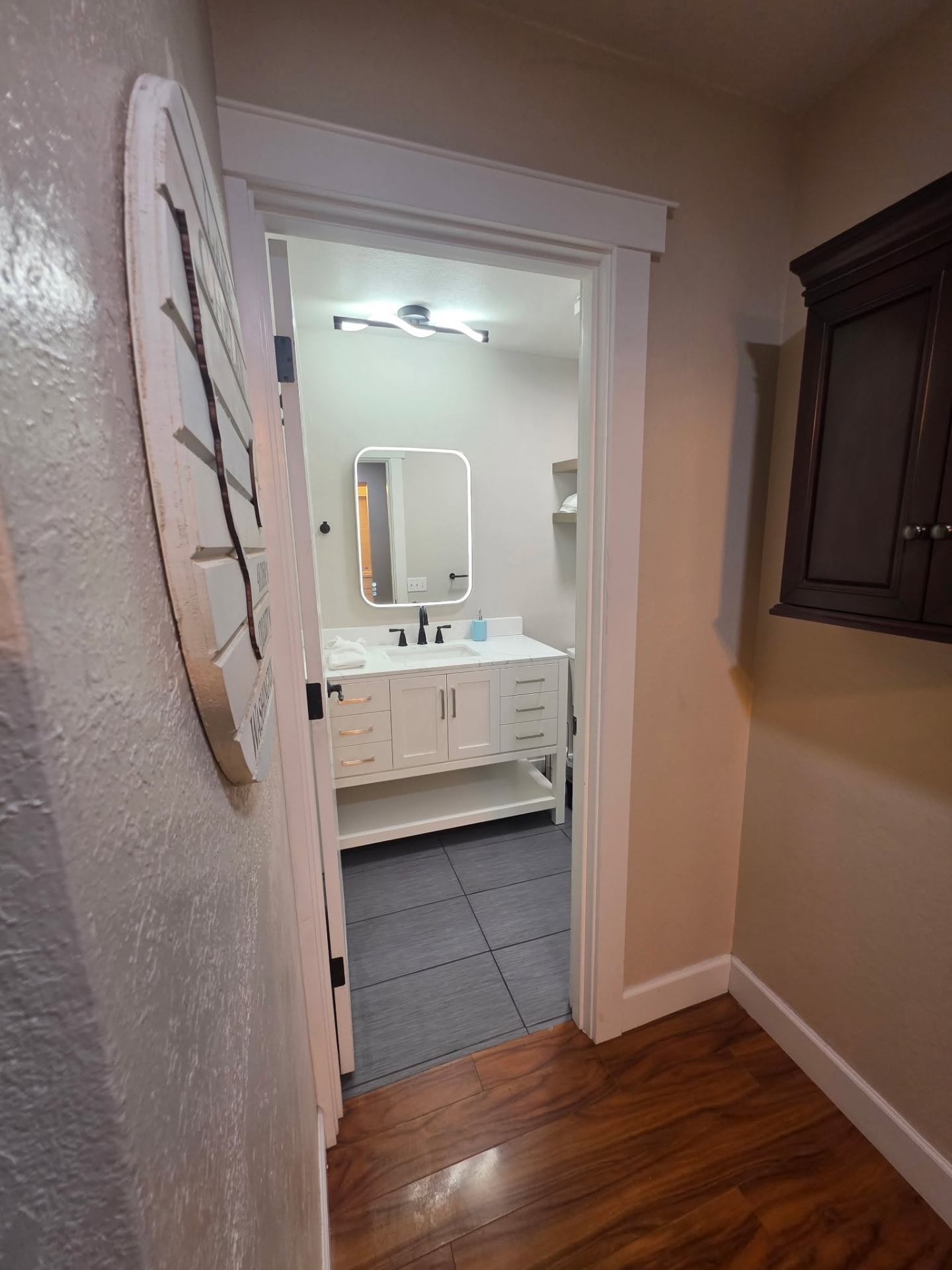 Bathroom doorway view of completed remodel with new flooring and trim