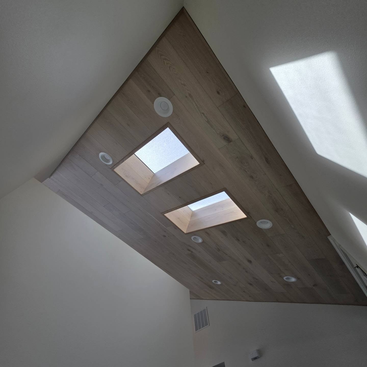 Vaulted white oak ceiling with two skylight returns in a Manson WA home