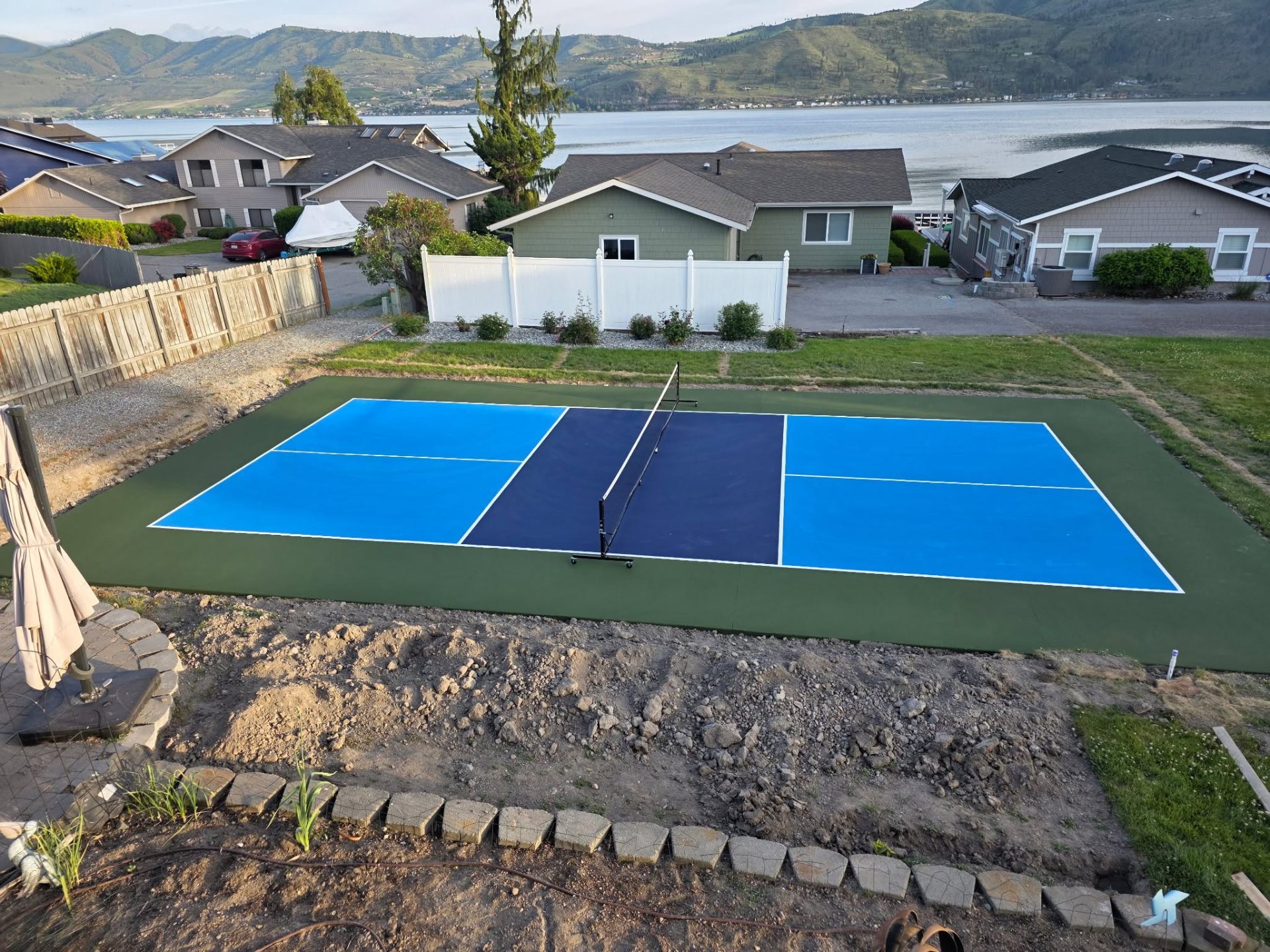 Side view of backyard pickleball court in Chelan WA with mountain backdrop
