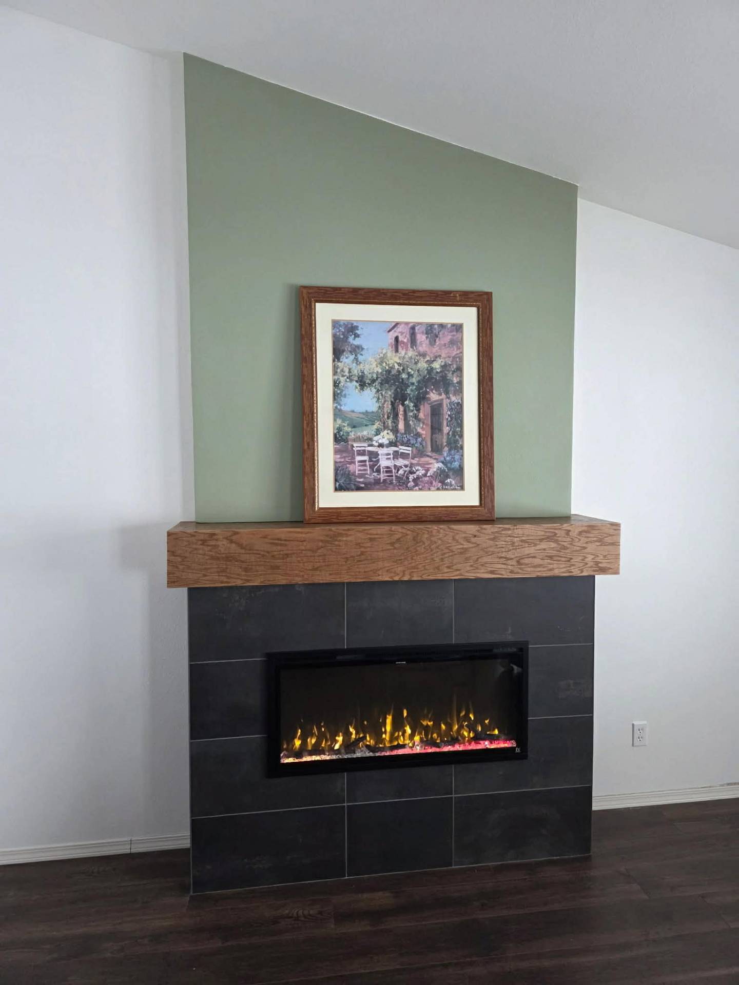 Slate tile fireplace surround with solid wood mantel and sage green accent wall in Chelan WA