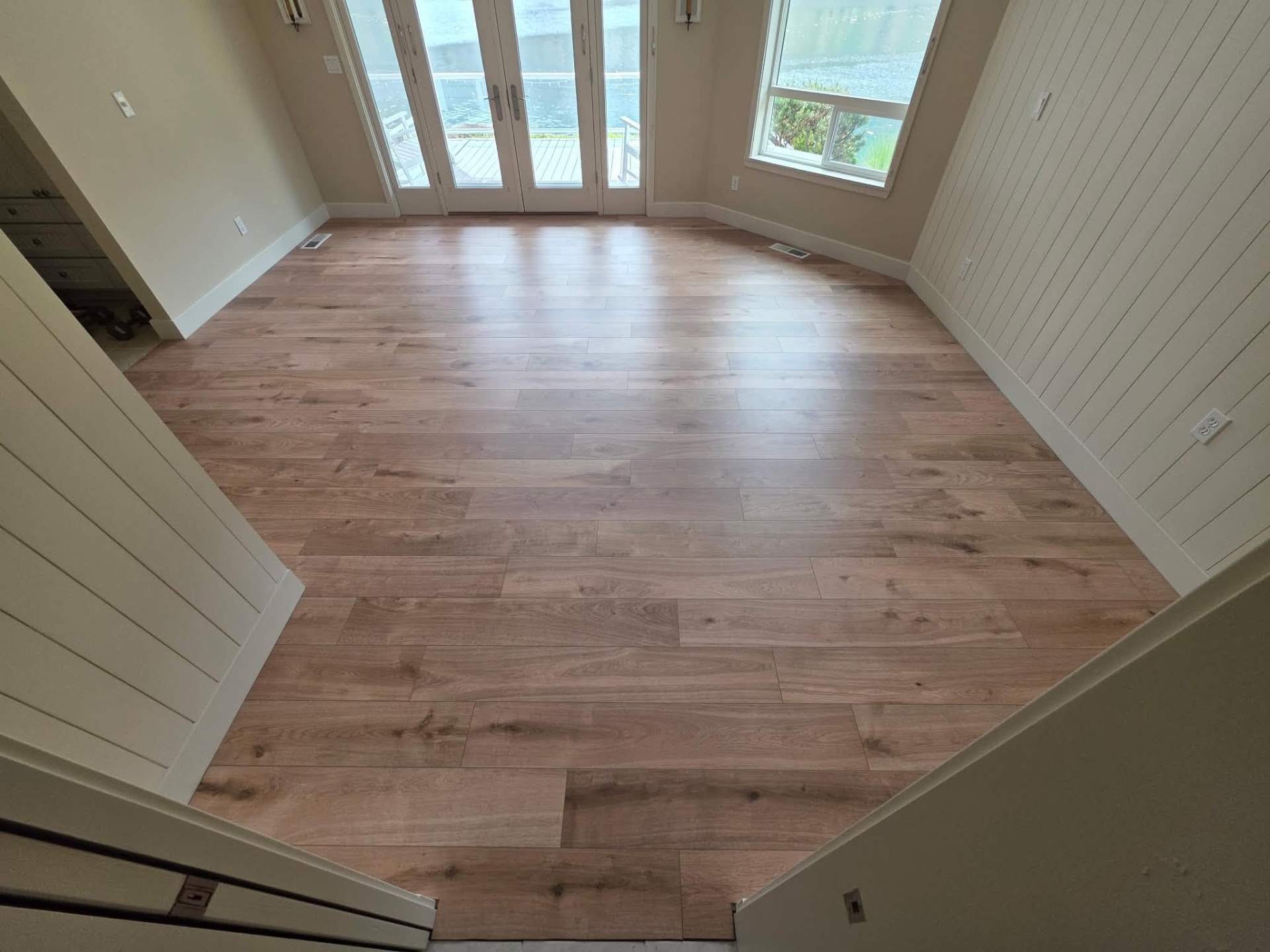 New luxury vinyl plank flooring in a Manson WA lake home with French doors to the deck