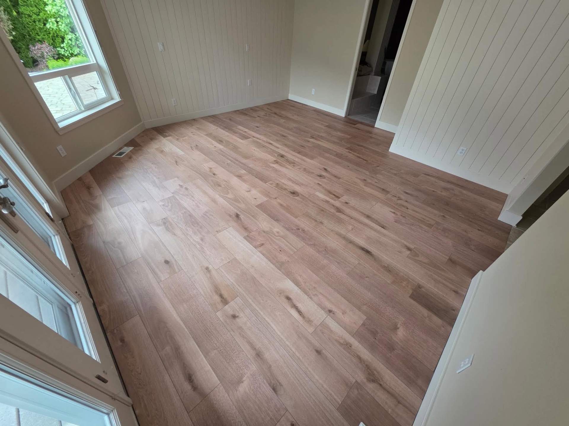 LVP flooring installation in a Manson home bedroom with shiplap walls